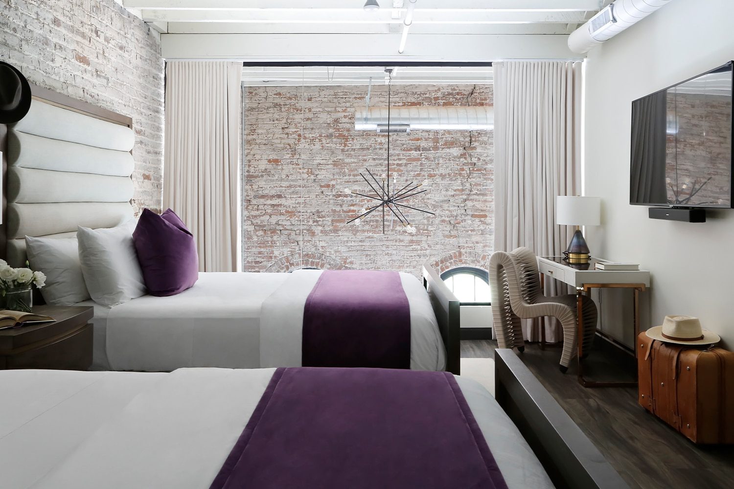 a bedroom with a bed and a chair in a room